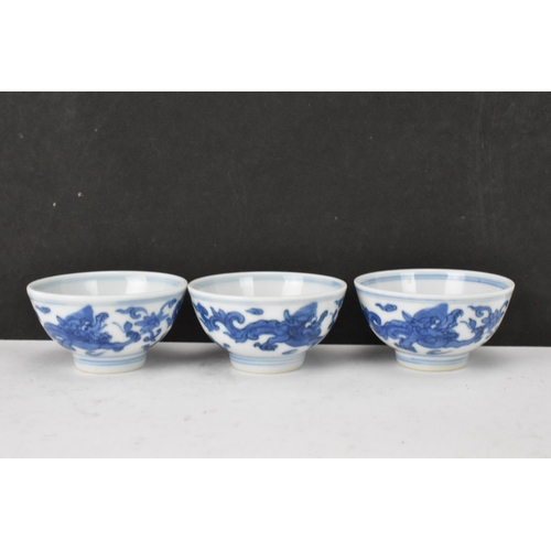 53 - Three Chinese 20th century blue and white bowls, decorated with dragons and interiors with central m... 