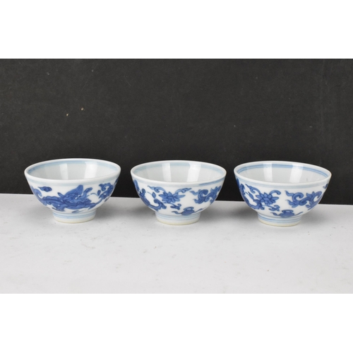 53 - Three Chinese 20th century blue and white bowls, decorated with dragons and interiors with central m... 