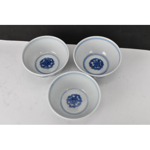 53 - Three Chinese 20th century blue and white bowls, decorated with dragons and interiors with central m... 