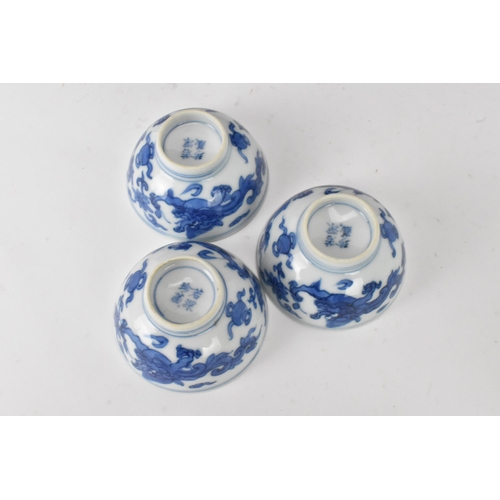 53 - Three Chinese 20th century blue and white bowls, decorated with dragons and interiors with central m... 