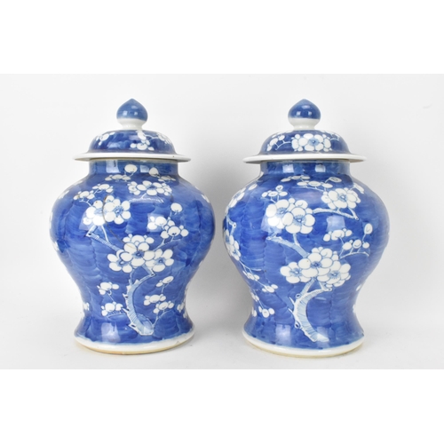 55 - A pair of Chinese prunus pattern blue and white vases, late Qing Dynasty, both of baluster form with... 