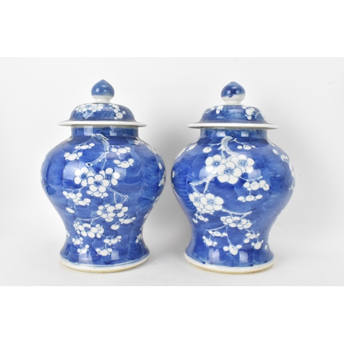 55 - A pair of Chinese prunus pattern blue and white vases, late Qing Dynasty, both of baluster form with... 