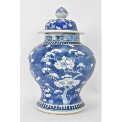 56 - A Chinese prunus pattern blue and white vase, late Qing Dynasty, of baluster form with domed cover a... 