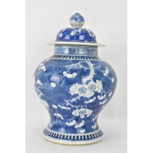 56 - A Chinese prunus pattern blue and white vase, late Qing Dynasty, of baluster form with domed cover a... 