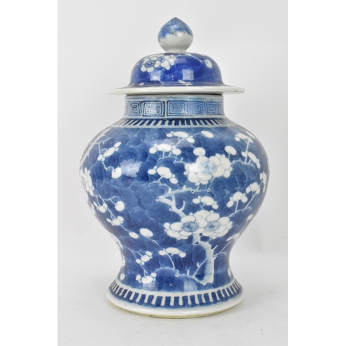 56 - A Chinese prunus pattern blue and white vase, late Qing Dynasty, of baluster form with domed cover a... 