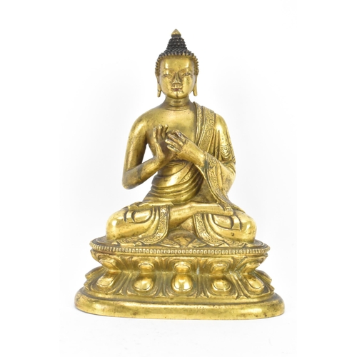 60 - A Sino Tibetian gilt bronze figure of Buddha, 18th/19th century, dressed in monastic robe, with hand... 