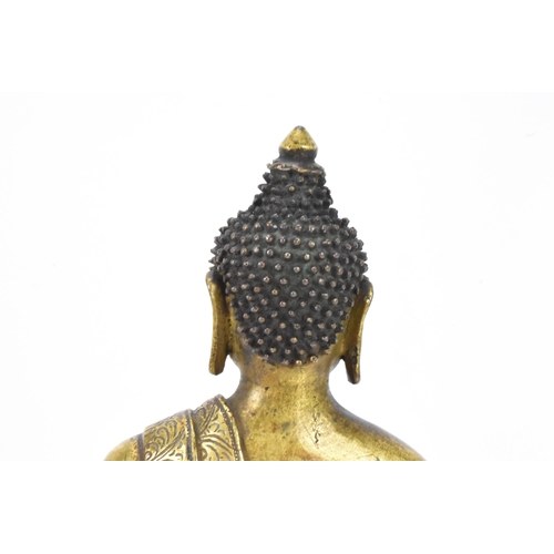 60 - A Sino Tibetian gilt bronze figure of Buddha, 18th/19th century, dressed in monastic robe, with hand... 