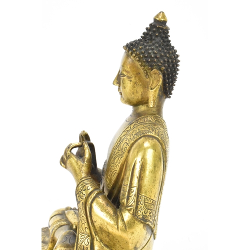 60 - A Sino Tibetian gilt bronze figure of Buddha, 18th/19th century, dressed in monastic robe, with hand... 