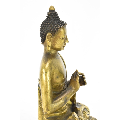 60 - A Sino Tibetian gilt bronze figure of Buddha, 18th/19th century, dressed in monastic robe, with hand... 