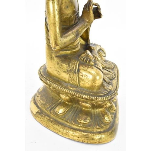 60 - A Sino Tibetian gilt bronze figure of Buddha, 18th/19th century, dressed in monastic robe, with hand... 