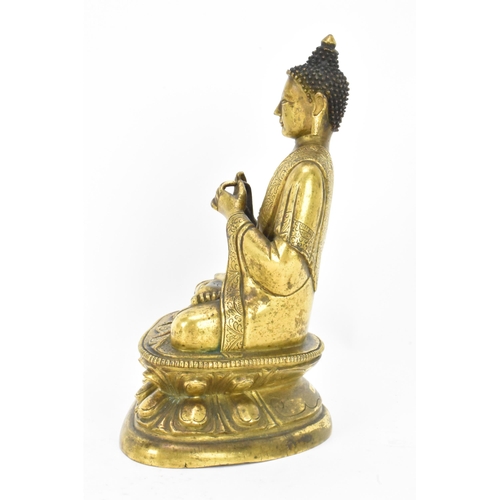 60 - A Sino Tibetian gilt bronze figure of Buddha, 18th/19th century, dressed in monastic robe, with hand... 