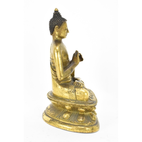 60 - A Sino Tibetian gilt bronze figure of Buddha, 18th/19th century, dressed in monastic robe, with hand... 