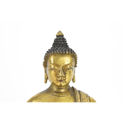 60 - A Sino Tibetian gilt bronze figure of Buddha, 18th/19th century, dressed in monastic robe, with hand... 