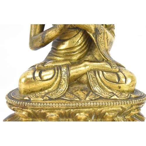 60 - A Sino Tibetian gilt bronze figure of Buddha, 18th/19th century, dressed in monastic robe, with hand... 