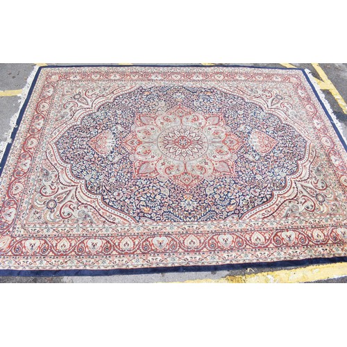 155 - An early 20th century handwoven Indian Agra rug, with central floral medallion on a navy ground, wit... 