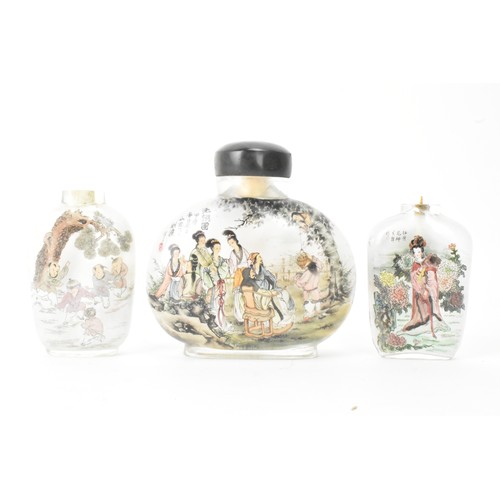 226 - Three Chinese 20th century glass painted snuff bottles, one depicting figures in conversation in a c... 