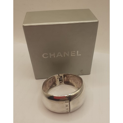 Chanel-A wide silver cuff bangle branded towards the opening and to the hinge, stamped 925 with grey branded jewellery box. 
Location: Cab
If there is no condition report shown, please request