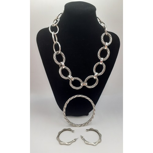 55 - A small group of silver jewellery comprising a large hoop chain necklace, a silver twist bangle and ... 