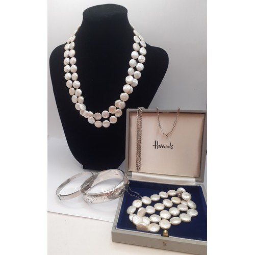 54 - A freshwater coin pearl 2-string necklace and matching bracelet having silver clasps, an engraved si... 