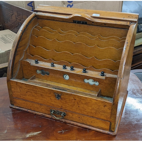 68 - A late Victorian oak table top letter/stationery cabinet having a tambour roll top, fitted interior ... 