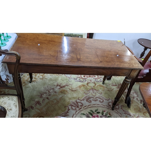 86 - A late Victorian Warring & Gillows style side table having two short drawers and reeded tapering leg... 