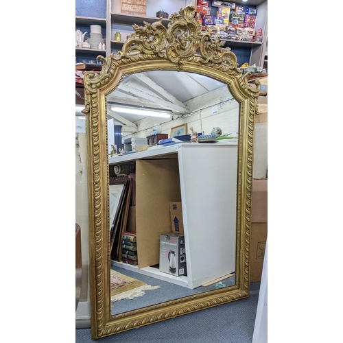 89 - A late 19th/early 20th century French ornate gilt mirror, decorated with C scrolls, beaded and gadro... 