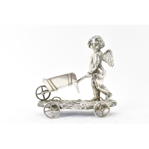 106 - A late Victorian silver plated novelty ornament, by Elkington & Co, fashioned as a cherub pushing a ... 