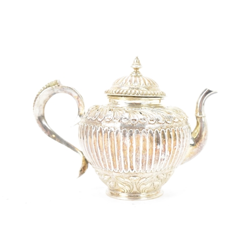 118 - A 19th century white metal small teapot, having a turned final, scroll handle with beading, embossed... 