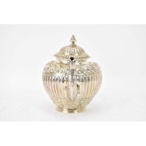 118 - A 19th century white metal small teapot, having a turned final, scroll handle with beading, embossed... 