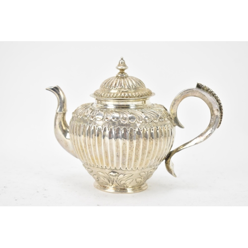 118 - A 19th century white metal small teapot, having a turned final, scroll handle with beading, embossed... 