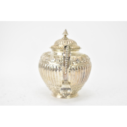 118 - A 19th century white metal small teapot, having a turned final, scroll handle with beading, embossed... 