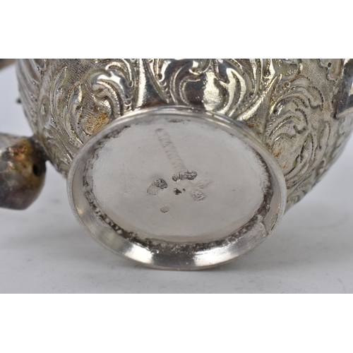 118 - A 19th century white metal small teapot, having a turned final, scroll handle with beading, embossed... 