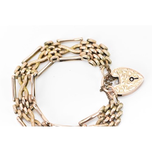 125 - A 9ct gold gate link bracelet, having a heart shaped locket with engraved detail and a safety chain,... 