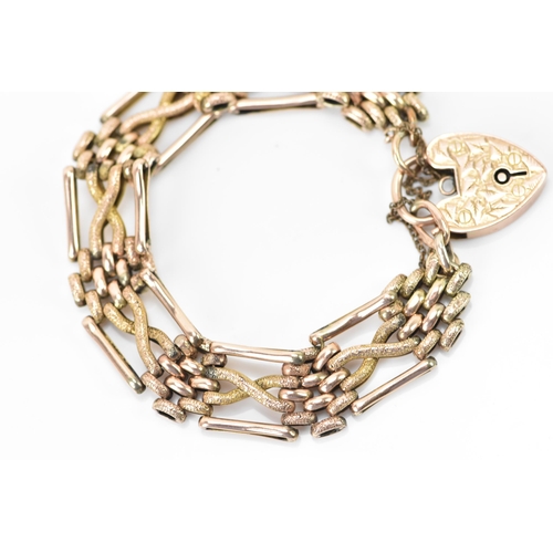 125 - A 9ct gold gate link bracelet, having a heart shaped locket with engraved detail and a safety chain,... 