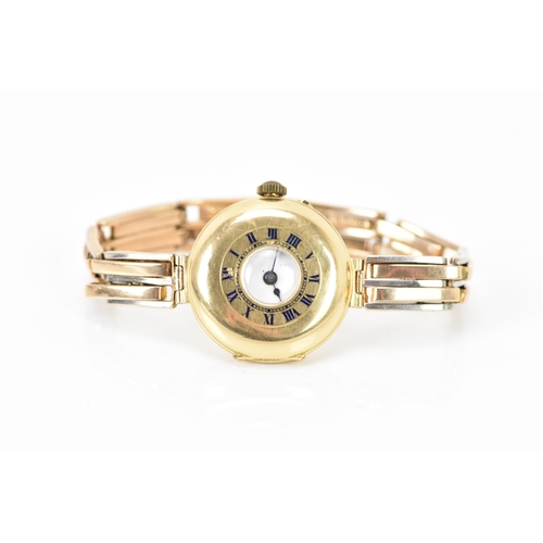 129 - An early 20th century 9ct yellow gold ladies watch, on a 9ct bi-coloured gold expanding bracelet, wh... 