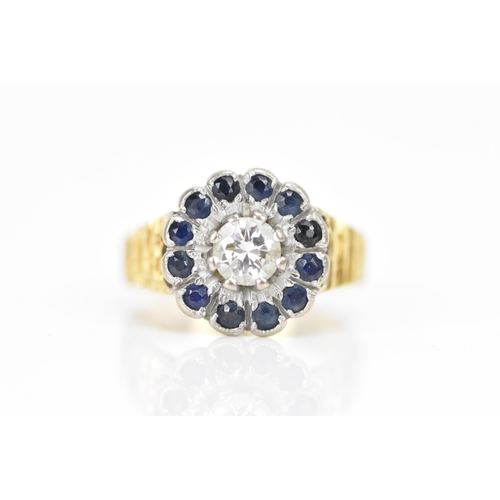 130A - An 18ct yellow and white gold sapphire and diamond cluster ring, the central brilliant cut diamond i... 