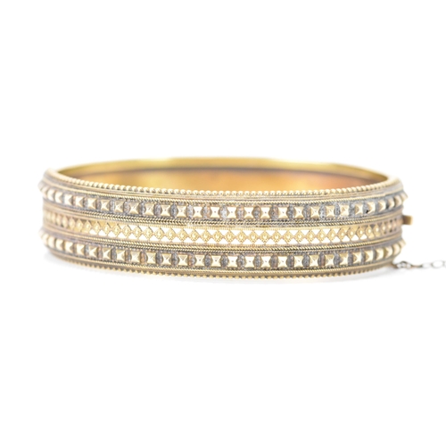 132 - A late Victorian 15ct yellow gold etruscan revival hinged bangle, circa 1880, having beaded rim, pie... 