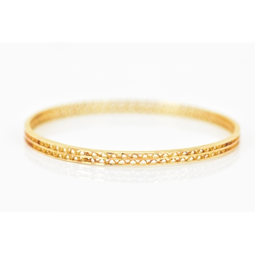 134 - An 18ct yellow gold bangle, having a pierced woven design and stamped N G F 18ct to the border, 7cm ... 