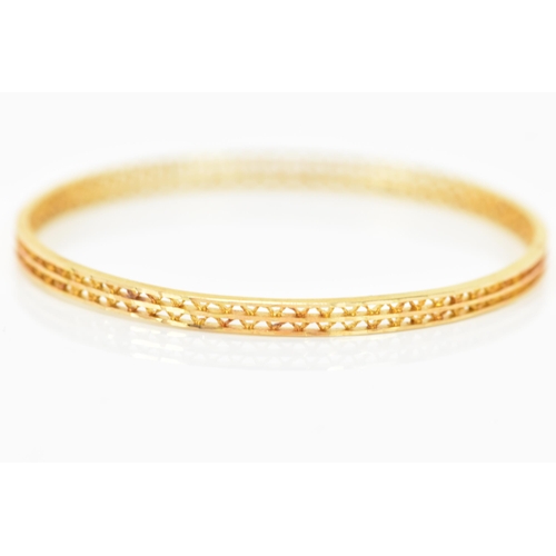 134 - An 18ct yellow gold bangle, having a pierced woven design and stamped N G F 18ct to the border, 7cm ... 