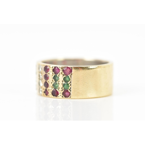 138 - A 9ct yellow and white gold ring, inset with rows of eight emeralds, sixteen rubies and twelve diamo... 