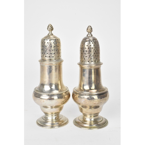 14 - A matched pair of George III silver shakers, one hallmarked London 1761 and the other London 1773, e... 