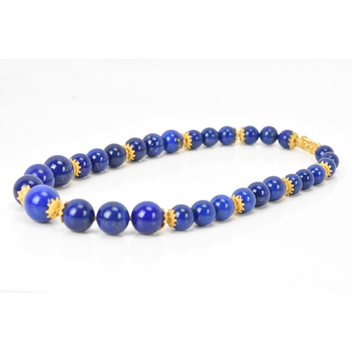 141 - A 14ct yellow gold and lapis lazuli beaded necklace, the rounded beads graduating in size, smallest ... 