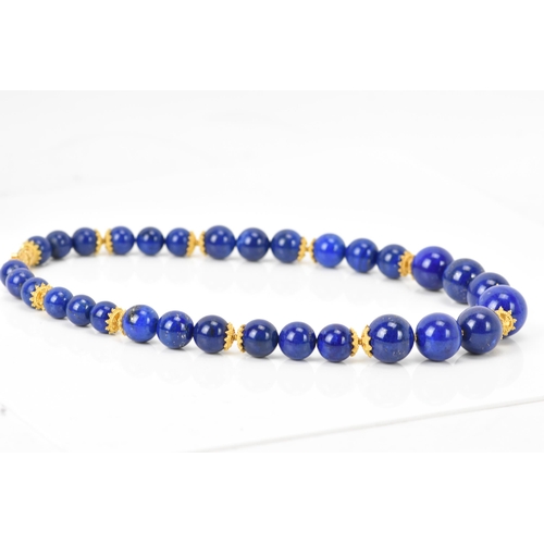 141 - A 14ct yellow gold and lapis lazuli beaded necklace, the rounded beads graduating in size, smallest ... 