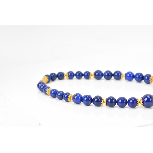 141 - A 14ct yellow gold and lapis lazuli beaded necklace, the rounded beads graduating in size, smallest ... 