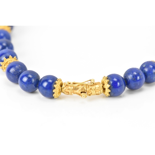 141 - A 14ct yellow gold and lapis lazuli beaded necklace, the rounded beads graduating in size, smallest ... 