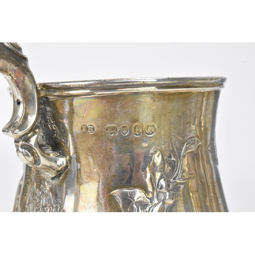 22 - A Victorian silver mug, by Robert Harper, hallmarked London 1857, the embossed baluster formed body ... 