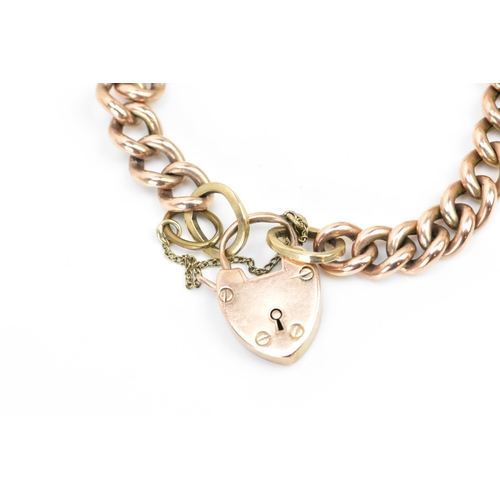 244 - A rose gold coloured curb link bracelet, with a safety chain and a 10ct gold hallmarked heart shaped... 