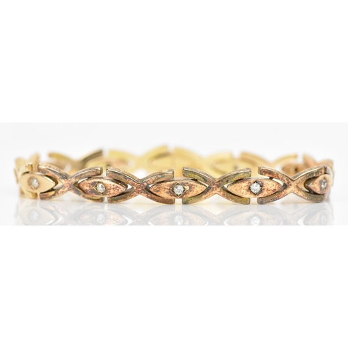 255 - A yellow gold and diamond bracelet, each of the oval links inset with a single diamond in a claw set... 