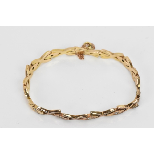 255 - A yellow gold and diamond bracelet, each of the oval links inset with a single diamond in a claw set... 