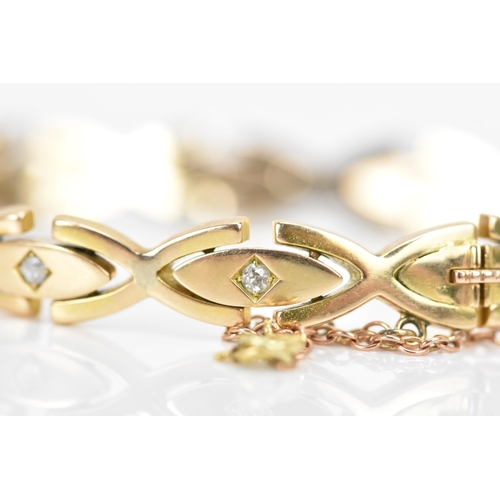 255 - A yellow gold and diamond bracelet, each of the oval links inset with a single diamond in a claw set... 